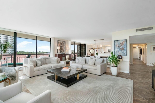 living room featuring an inviting chandelier and expansive windows