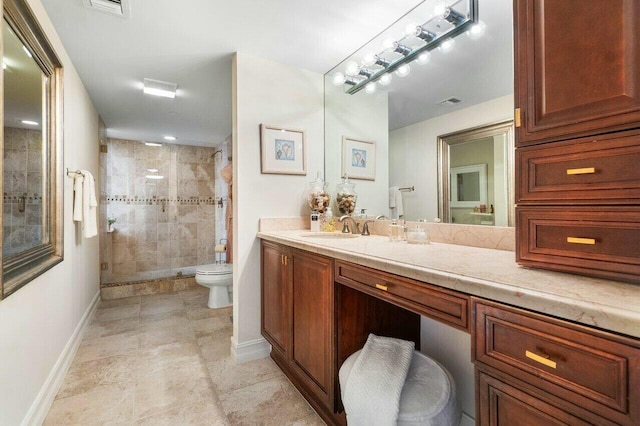 bathroom with toilet, vanity, and tiled shower