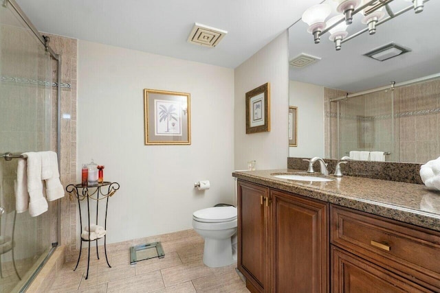 bathroom with toilet, vanity, and an enclosed shower