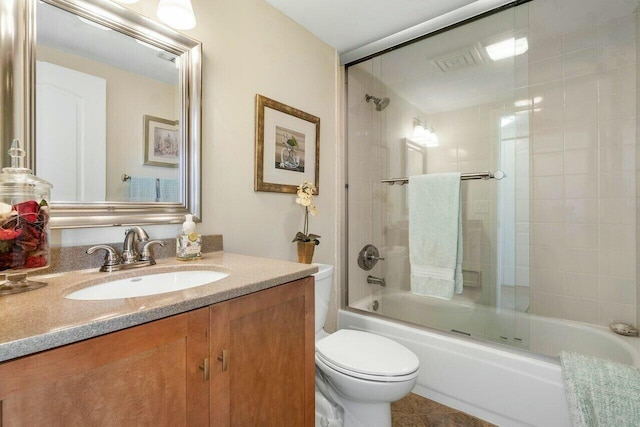 full bathroom featuring combined bath / shower with glass door, vanity, toilet, and tile patterned flooring