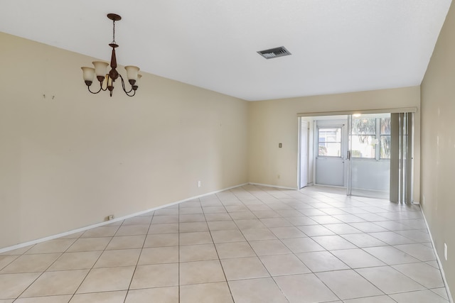 spare room featuring light tile patterned floors and a chandelier