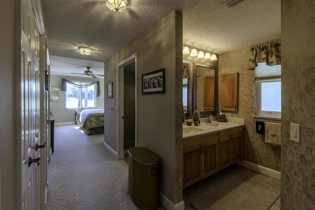 bathroom featuring ceiling fan, vanity, and a textured ceiling