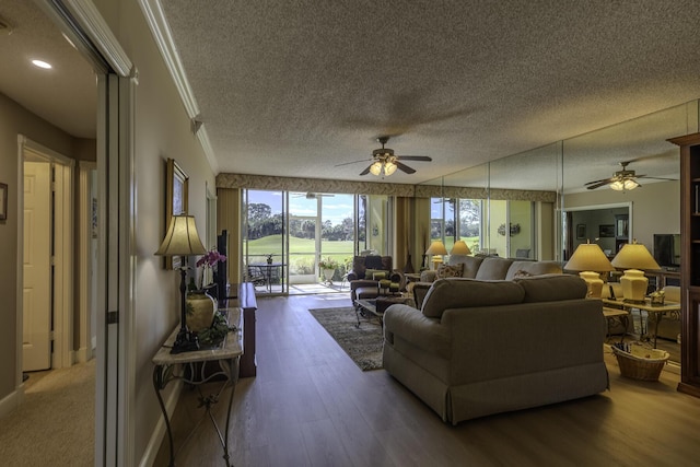 living room featuring hardwood / wood-style floors, ceiling fan, ornamental molding, and a textured ceiling