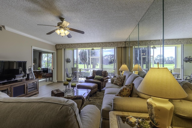 living room with ceiling fan, crown molding, wood-type flooring, and a textured ceiling