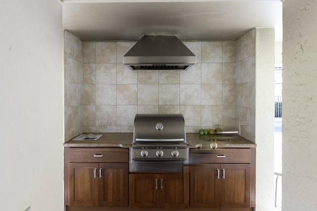 kitchen featuring tasteful backsplash and wall chimney range hood