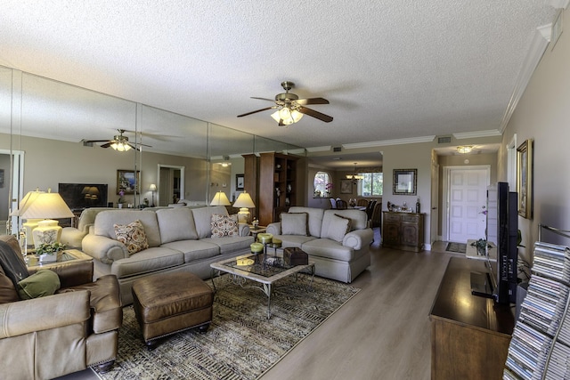 living room featuring dark hardwood / wood-style floors, ceiling fan, ornamental molding, and a textured ceiling