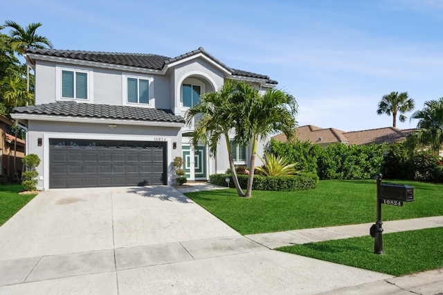 mediterranean / spanish house with a garage and a front lawn