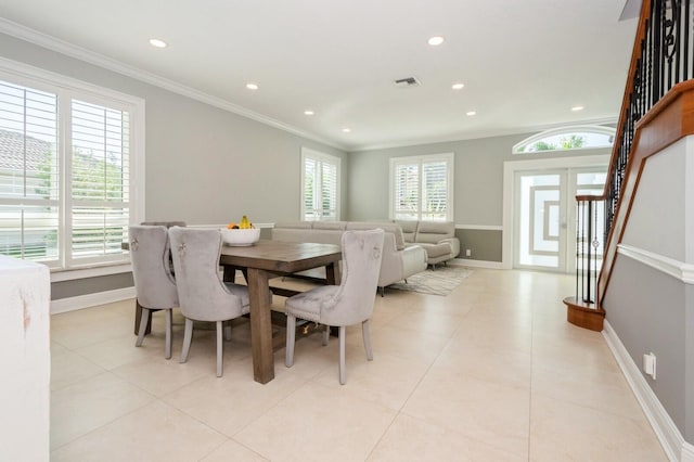 dining area with light tile patterned floors, plenty of natural light, and ornamental molding