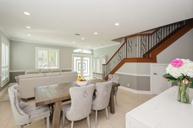 dining space with light tile patterned floors, crown molding, and french doors