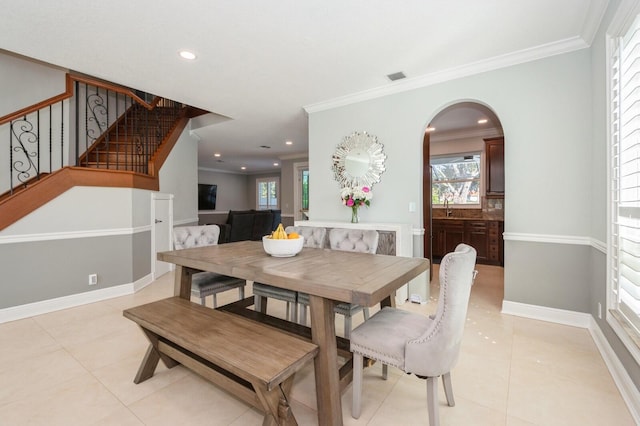 tiled dining room with sink and crown molding