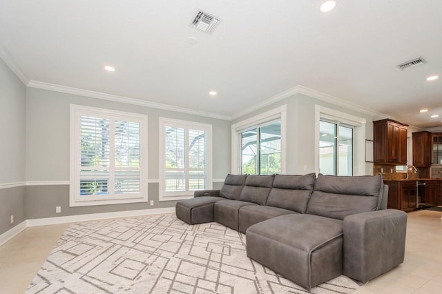 living room featuring light tile patterned floors, ornamental molding, and sink