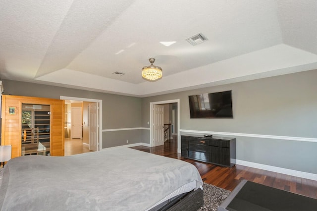 bedroom featuring dark hardwood / wood-style floors and a raised ceiling