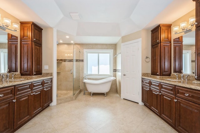 bathroom with a tray ceiling, vanity, and independent shower and bath