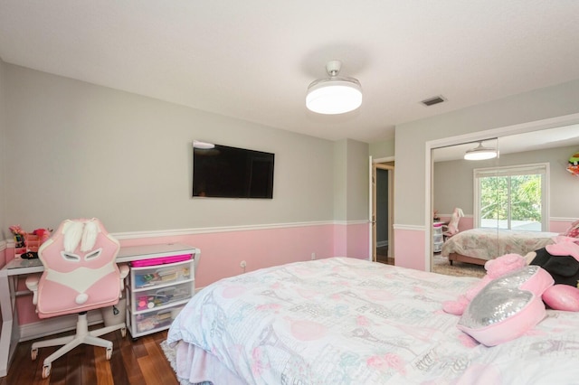 bedroom featuring dark hardwood / wood-style flooring, ceiling fan, and a closet