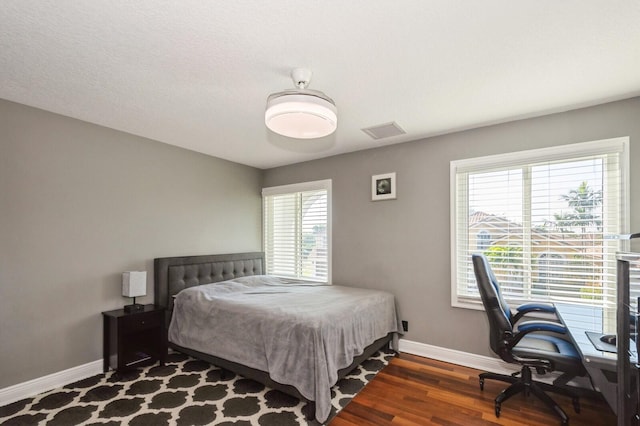 bedroom with dark hardwood / wood-style floors