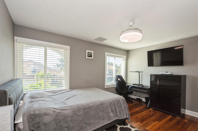 bedroom with dark hardwood / wood-style flooring