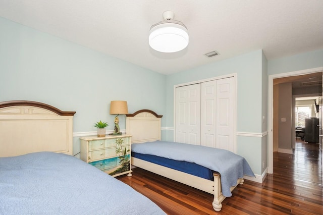 bedroom with dark hardwood / wood-style flooring, ceiling fan, and a closet