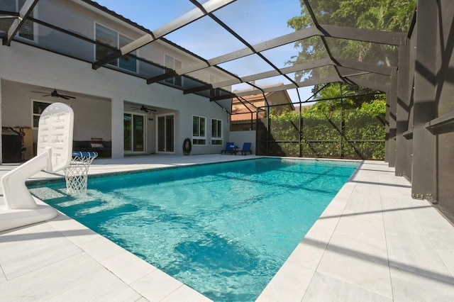 view of pool featuring ceiling fan, a patio, and glass enclosure