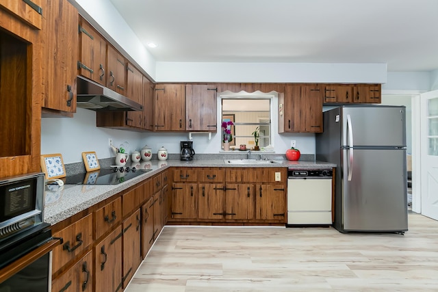 kitchen featuring sink, black appliances, and light hardwood / wood-style floors