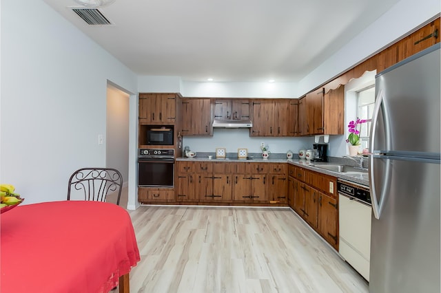 kitchen with sink, black appliances, and light hardwood / wood-style floors