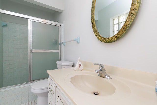 bathroom with an enclosed shower, vanity, and toilet