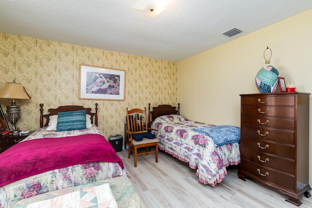 bedroom featuring a textured ceiling and light wood-type flooring