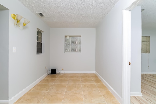 laundry room with light tile patterned floors and a textured ceiling