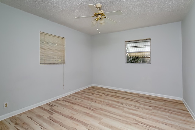 empty room with ceiling fan, light hardwood / wood-style flooring, and a textured ceiling