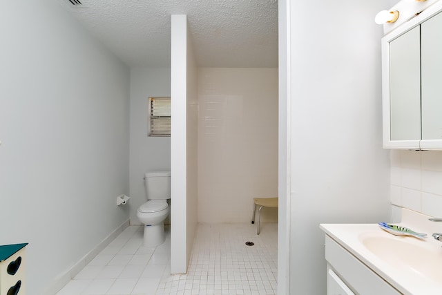 bathroom with vanity, toilet, and a textured ceiling