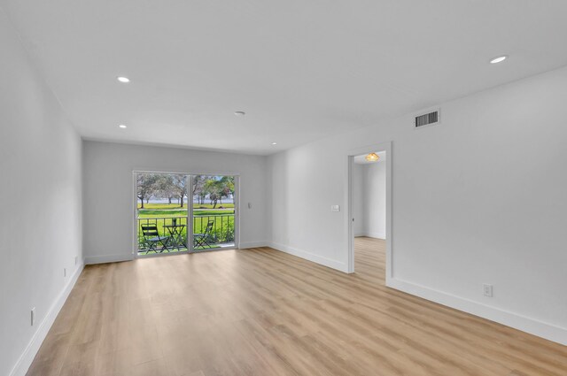 empty room with an inviting chandelier and light hardwood / wood-style flooring