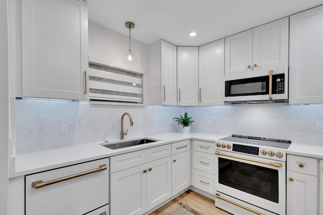 kitchen with sink, white cabinets, hanging light fixtures, and white appliances