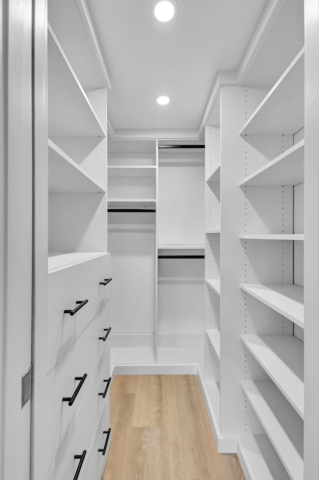 walk in closet with light hardwood / wood-style flooring