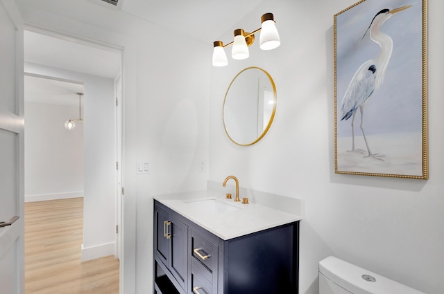 bathroom featuring vanity, hardwood / wood-style flooring, and toilet