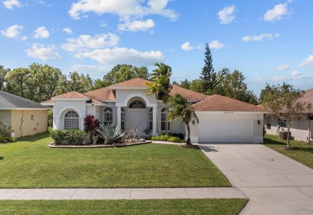 mediterranean / spanish house with a front yard and a garage