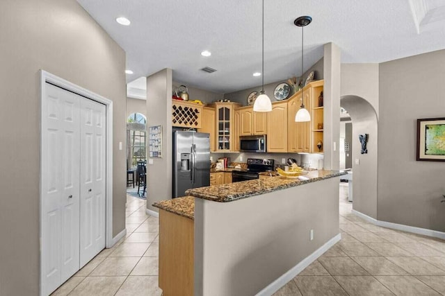 kitchen with kitchen peninsula, pendant lighting, dark stone counters, light tile patterned floors, and appliances with stainless steel finishes