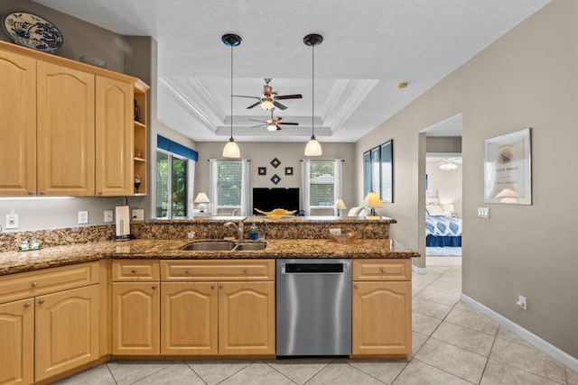 kitchen with pendant lighting, dishwasher, dark stone counters, a raised ceiling, and sink