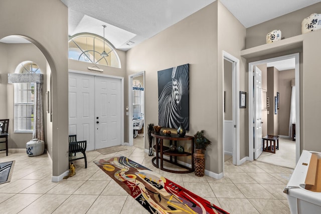 foyer featuring a towering ceiling and light tile patterned floors