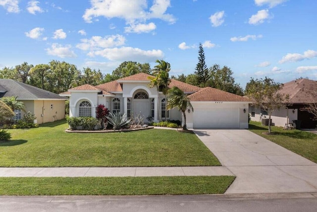 mediterranean / spanish-style home with a garage and a front lawn