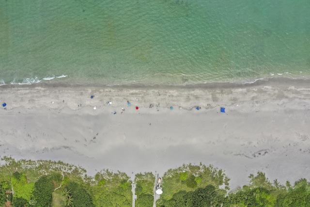 birds eye view of property featuring a beach view and a water view