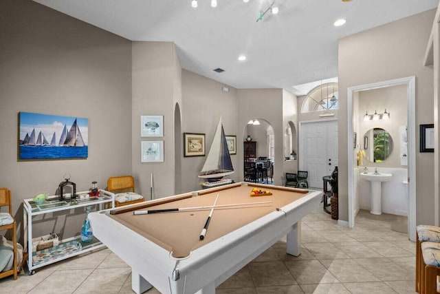 rec room featuring light tile patterned floors, sink, billiards, and a towering ceiling