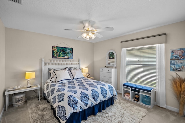 bedroom featuring ceiling fan, carpet, and a textured ceiling