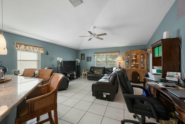 living room featuring a healthy amount of sunlight, light tile patterned floors, lofted ceiling, and ceiling fan