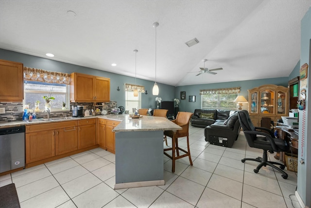 kitchen with lofted ceiling, dishwasher, a breakfast bar, kitchen peninsula, and hanging light fixtures