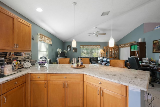 kitchen with ceiling fan, kitchen peninsula, vaulted ceiling, and a kitchen breakfast bar