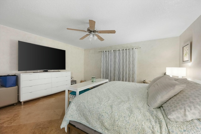 bedroom with ceiling fan and a textured ceiling