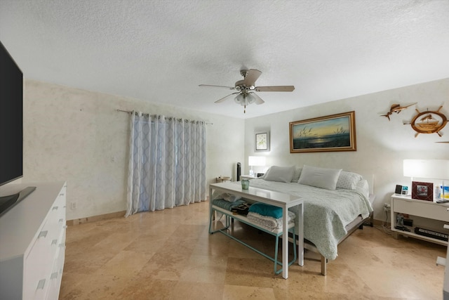 bedroom with ceiling fan and a textured ceiling