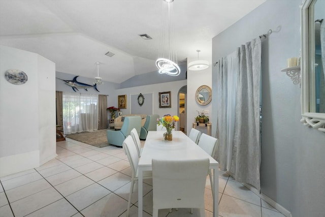 tiled dining room featuring lofted ceiling