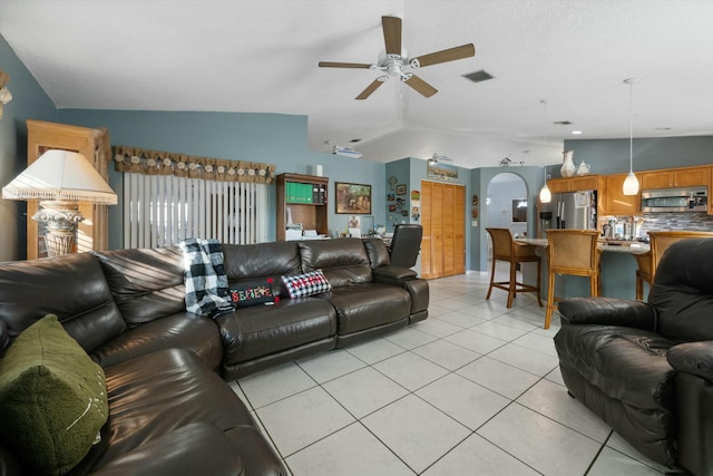 living room featuring ceiling fan, light tile patterned flooring, and lofted ceiling