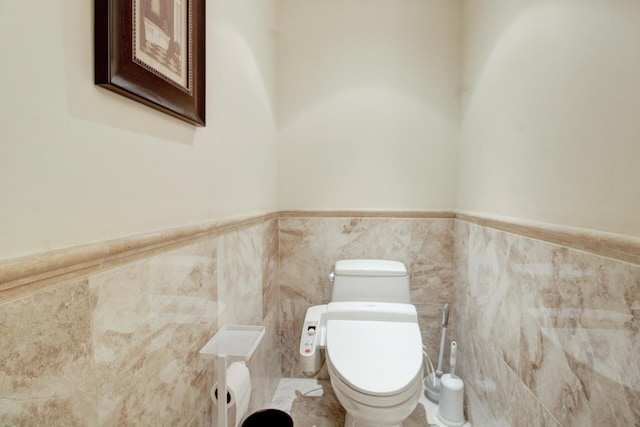 bathroom with toilet and tile walls