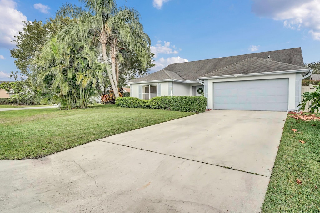 single story home with a front lawn and a garage